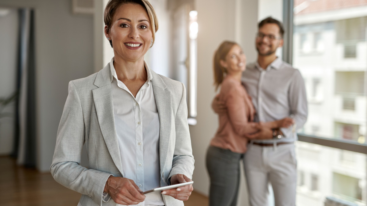 une jeune femme professionnelle de l'immobilier conseille un couple